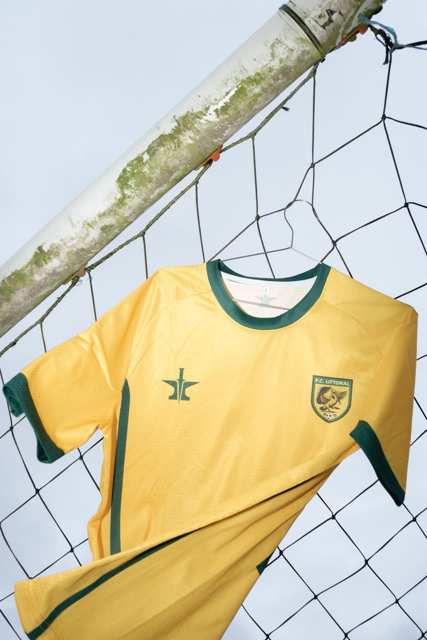 Maillot domicile joueur du F.C. Littoral par Lemnos — jaune à liserés verts, emblème Lemnos et blason du club, vue de face